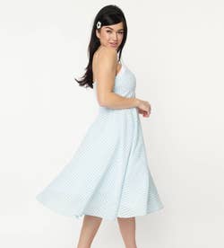 side view of model wearing the white and blue gingham dress