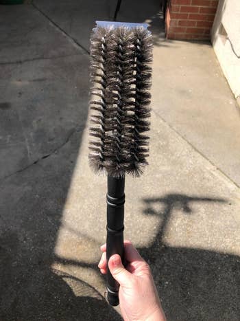 reviewer holding the grill brush