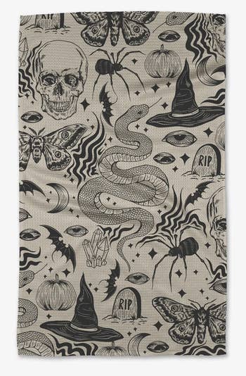 a grayscale halloween collage towel with skulls, spiders, witch's hats, gravestones, and more