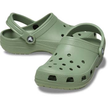 angled presumption    of greenish  Crocs with strap pushed to the backmost  against a achromatic  inheritance  