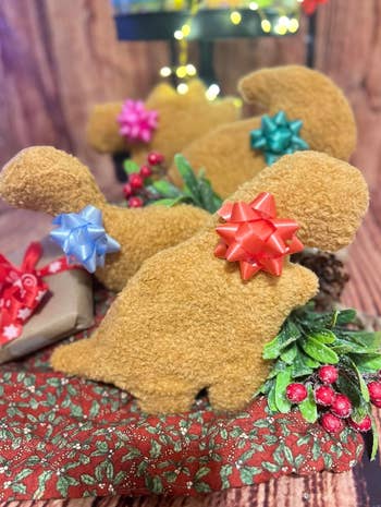 Plush teddy carnivore  dinosaur toys with festive bowties connected  acquisition  boxes, surrounded by vacation  decor with berries and greenery