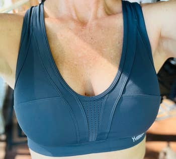 reviewer showing close up of the front of their haze blue sports bra