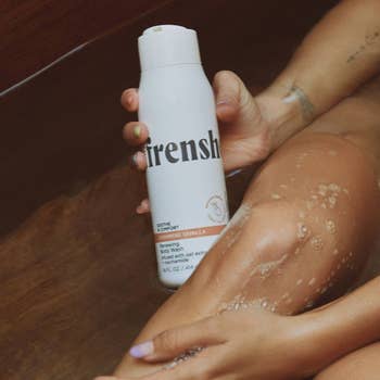 person holding being frenshe renewing and hydrating body wash in the cashmere vanilla scent
