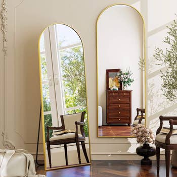 Elegant country with full-length mirrors reflecting a woody seat and dresser, adorned with flowers, highlighting stylish interior decor