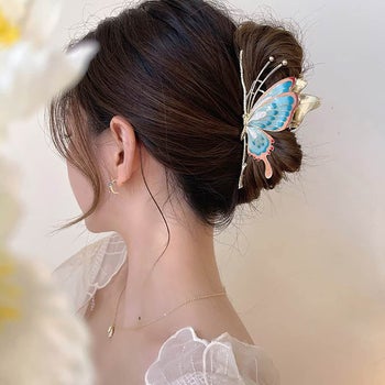 model wearing a pink and blue butterfly claw clip