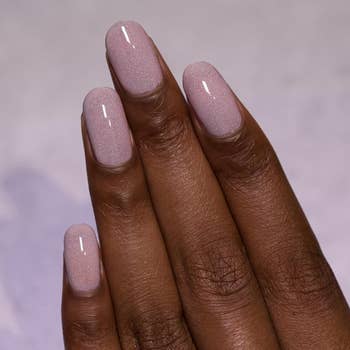 a hand with a darker skin tone and oval shaped nails wearing the polish 