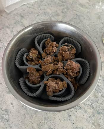 reviewer's dog food tucked between the pockets of the silicone 