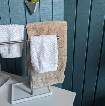Reviewer pic of the towel holder with three hand towels on it
