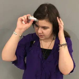 BuzzFeeder applying the migraine stick to their forehead