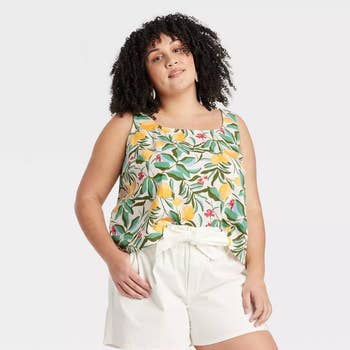 model posing in a floral linen tank top and white shorts
