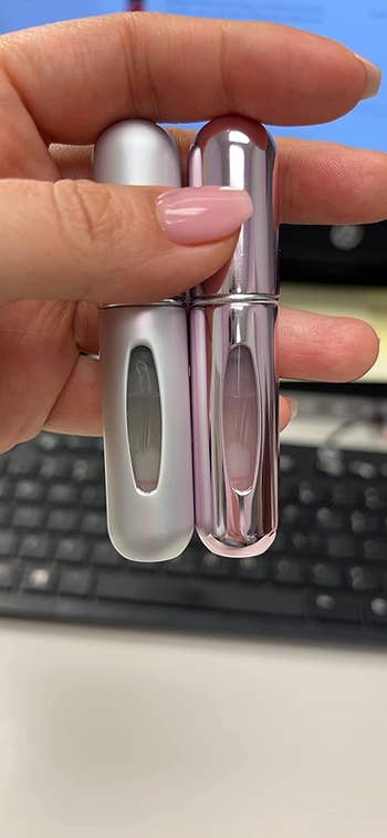 image of reviewer holding up two mini spray bottles