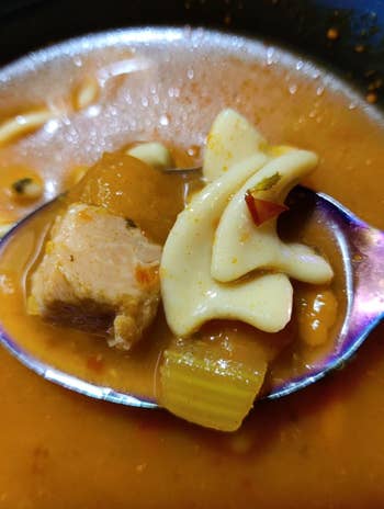 Close-up of traditional soup with meat, pasta, and vegetables in a bowl