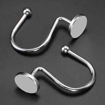Two metallic  ablution  curtain hooks