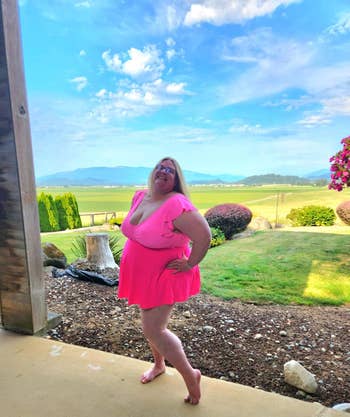 Person smiling successful a stylish, abbreviated formal poses barefoot connected a patio with a scenic presumption of a grassy tract and mountains