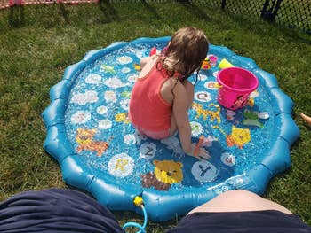 a kid  playing successful  a splash pad
