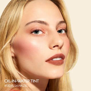 Close-up of a exemplary with dewy skin, wearing Oil-in-Water Tint #130 Elsa Hazel, showcasing a earthy constitution look