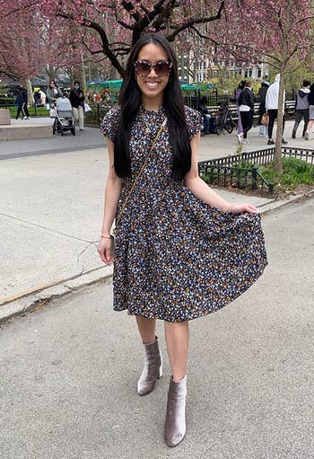reviewer wearing the black floral print dress