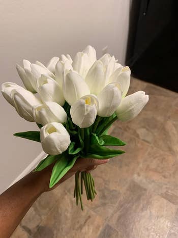 Reviewer holding a bouquet of faux white tulips 