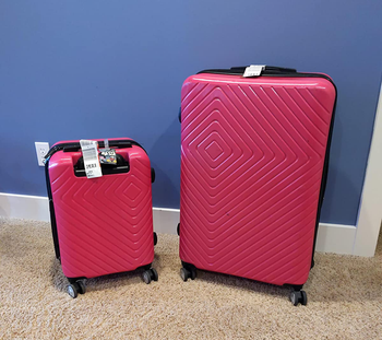 reviewer photo of smaller and larger pink hardshell suitcases