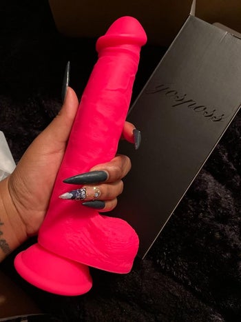 Reviewer holding pink dildo