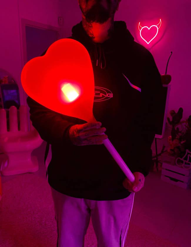 Person holding a ample heart-shaped light