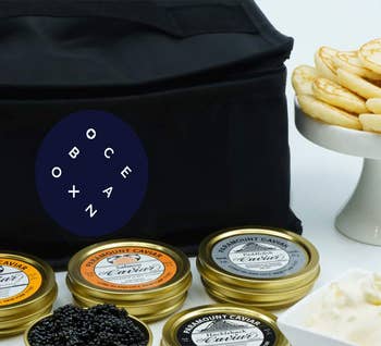 carrier bag beside tins of caviar, creme fresh, and blinis