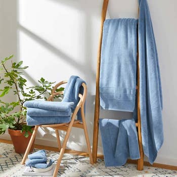 the blue towels arranged on a wooden rack and chair
