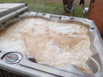 Outdoor hot tub with dirt brown foam buildup