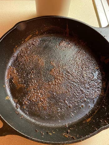 before photo of a cast-iron skillet coated in food