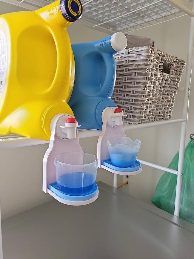 Laundry country   setup with detergent dispensers, 1  pouring bluish  liquid into a cup, adjacent  to a woven basket