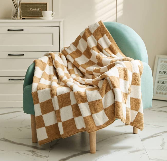 checker print blanket in brown on turquoise armchair