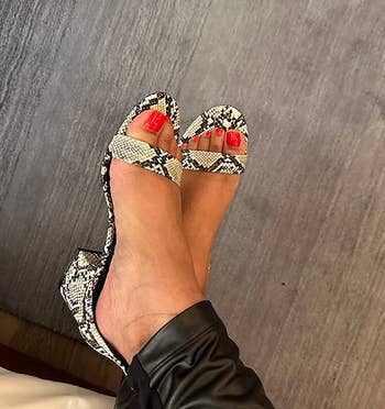 image of reviewer wearing the snake print sandals