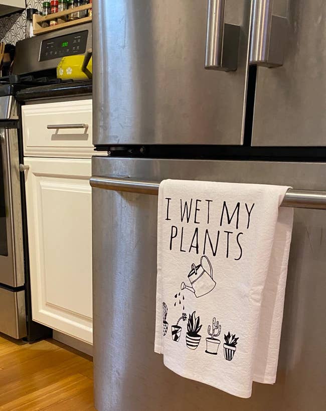 white towel with illustration illustration of a watering can watering plants and text 