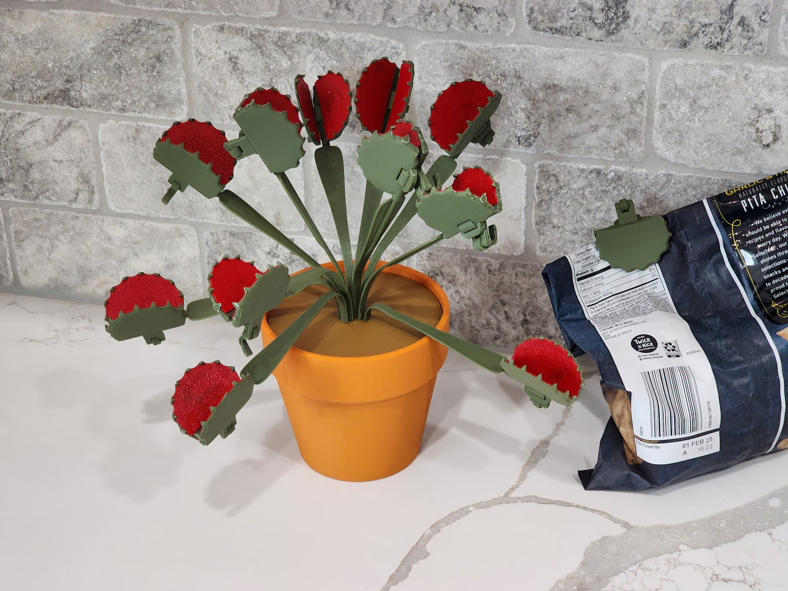 3d printed bouquet of Venus flytrap clips beside a container  of chips clipped closed