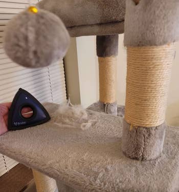 the triangle pet hair tool and fur collected on a cat tower