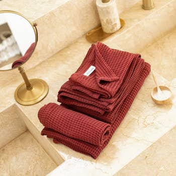 the sumac colored towel set folded on a marble surface
