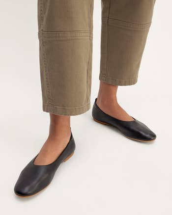 Person wearing ankle-length pants and black slip-on flats