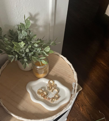 reviewer's white cloud tray holding gold jewelry 