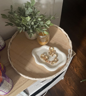 reviewer's white cloud tray holding gold jewelry 