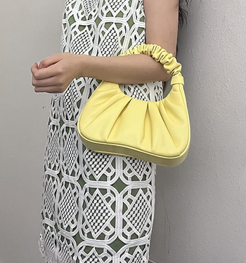 reviewer holding the bag in the light yellow color