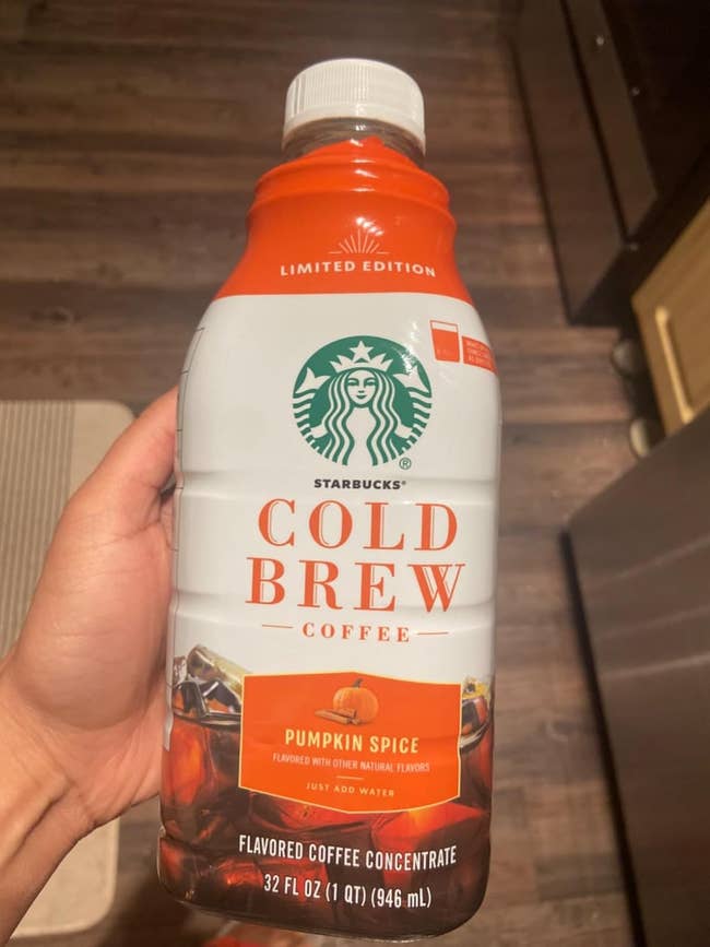 Starbucks Cold Brew ore  vessel  successful  Pumpkin Spice spirit  held successful  a person’s hand, suitable for making flavored java  drinks