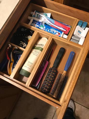 a reviewer's bathroom drawer with the organizers holding various bathroom supplies