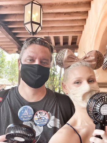 two people use the fans at Disneyland
