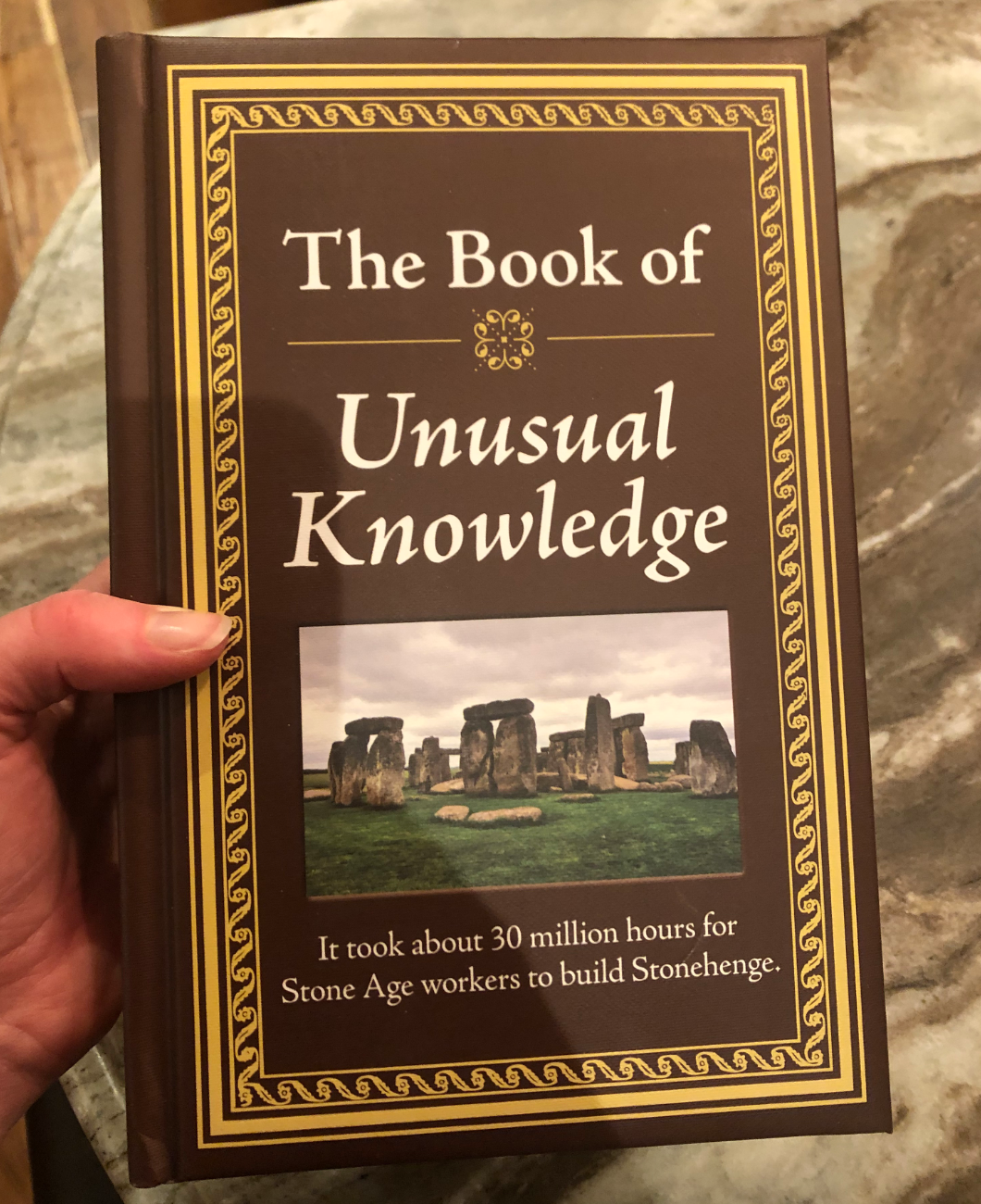 reviewer holding the book of unusual knowledge