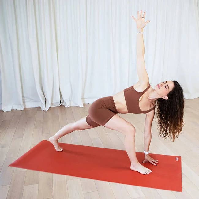 a model doing yoga on an orange mat 
