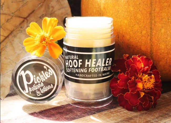 Tube of Natural hoof healer softening foot balm surrounded by flowers