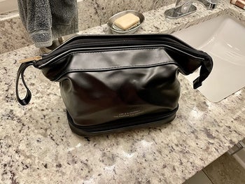 reviewer photo of black faux leather toiletry bag