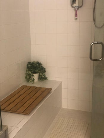 another reviewer's photo of the bath mat placed on a built-in shower bench
