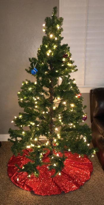 a reviewer's tree with a shimmery red tree skirt
