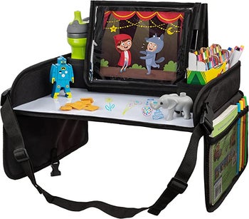 A closeup of the table with toys, a tablet, water bottle, art supplies and other items stored